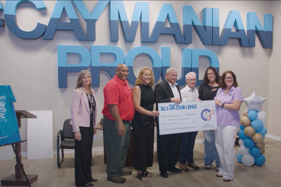 Deputy Governor of the Cayman Islands Franz Manderson presents cheque as part of the DG's 5K 2025